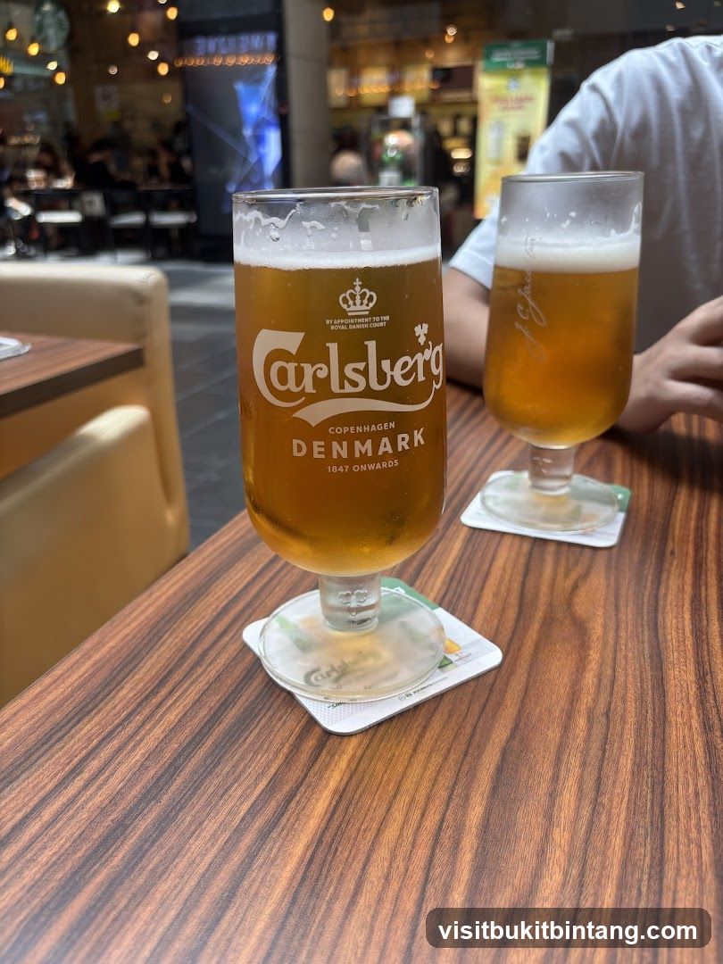 Two glasses of Carlsberg beer on a wooden table