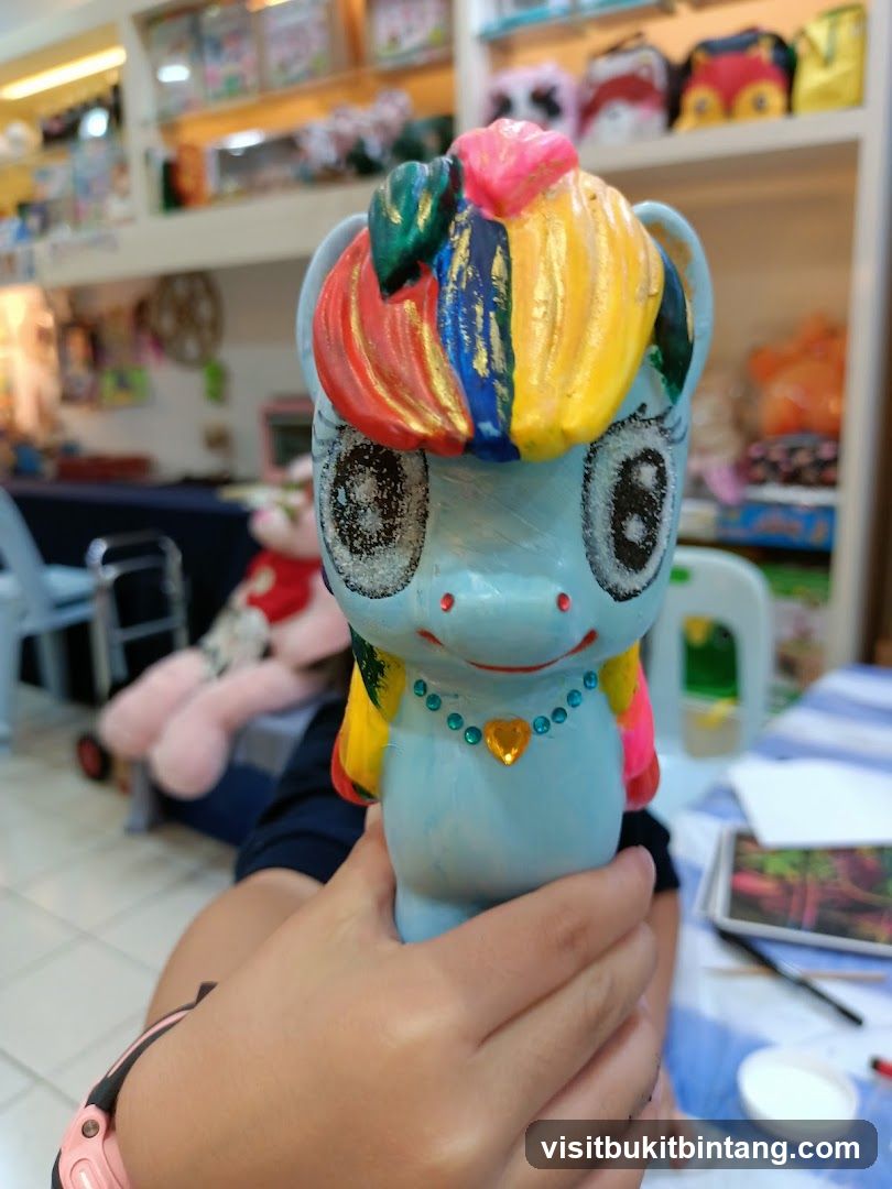 Hand holding a painted ceramic pony figurine