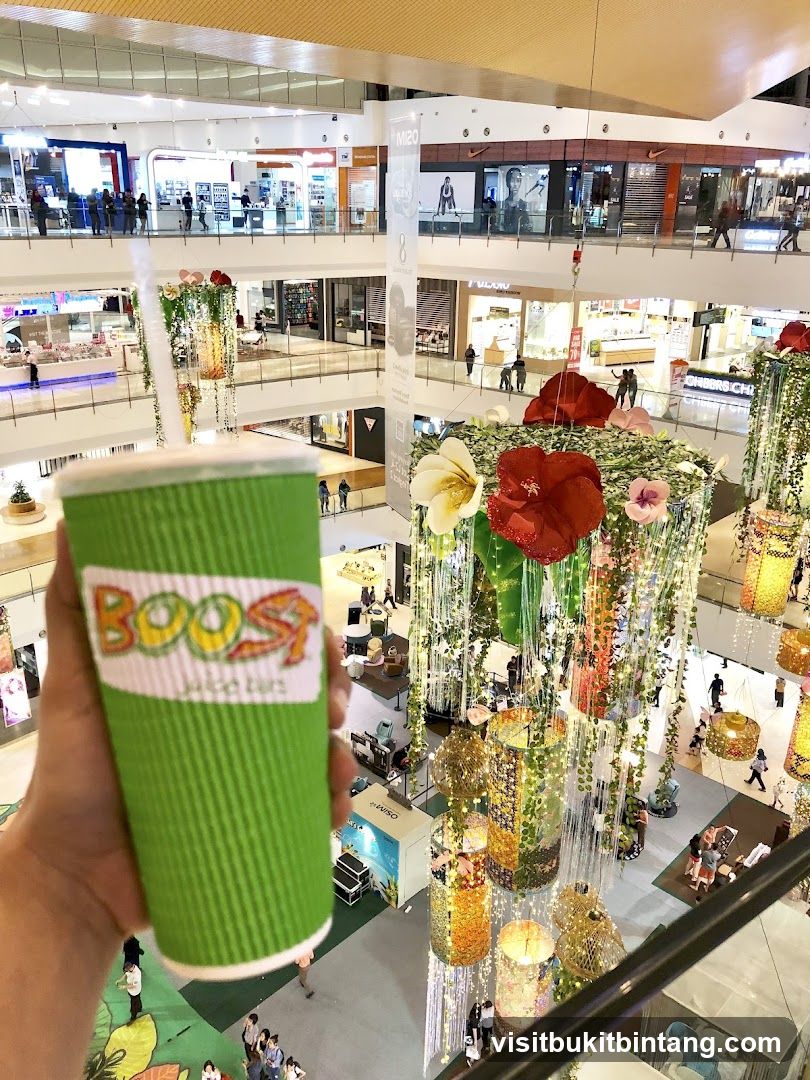 Hand holding a Boost Juice cup in a mall