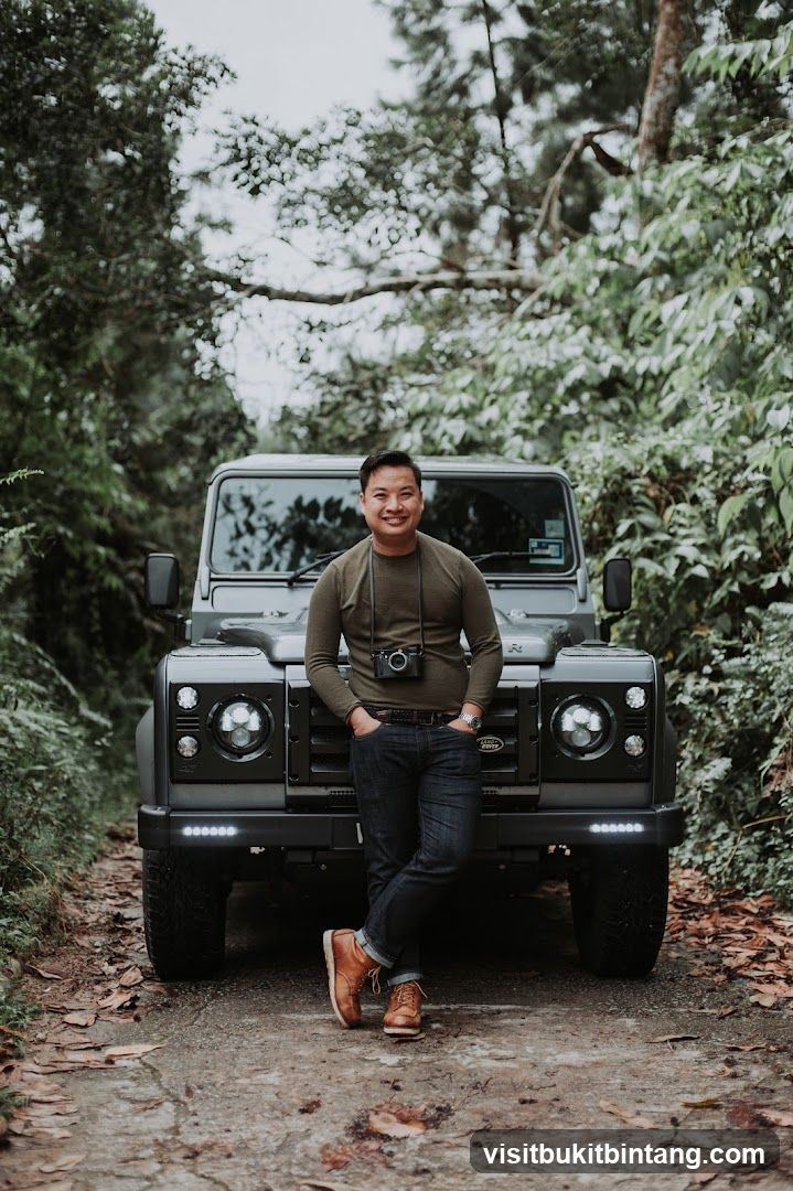 Man Posing with a Land Rover in a Forest