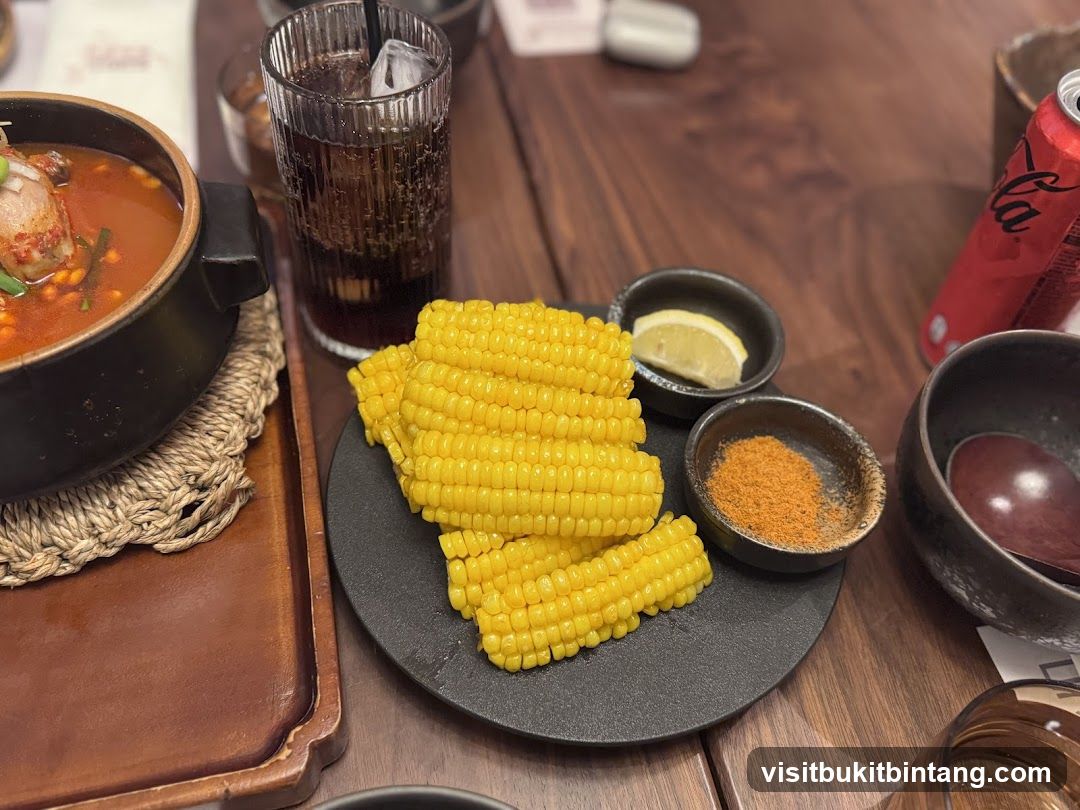 Corn on the cob with dipping spices and a drink