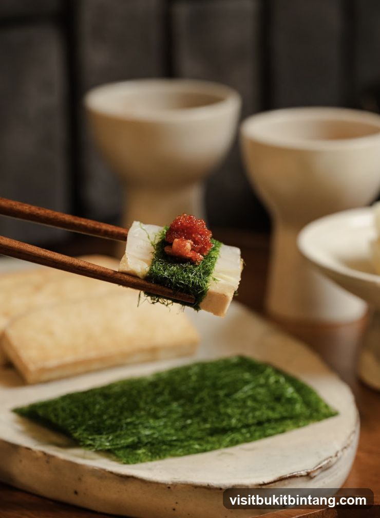Close-up of a sushi roll being held by chopsticks