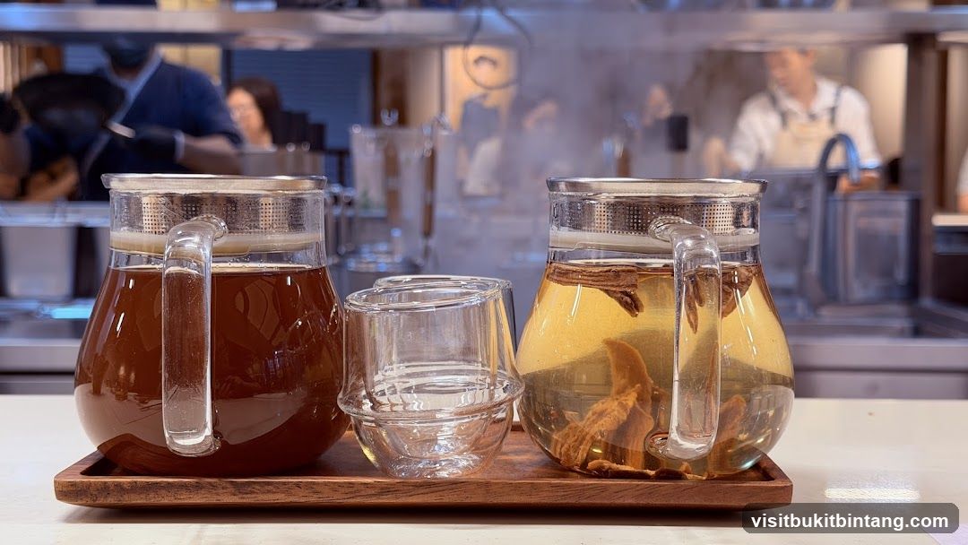Two pitchers of tea and a glass