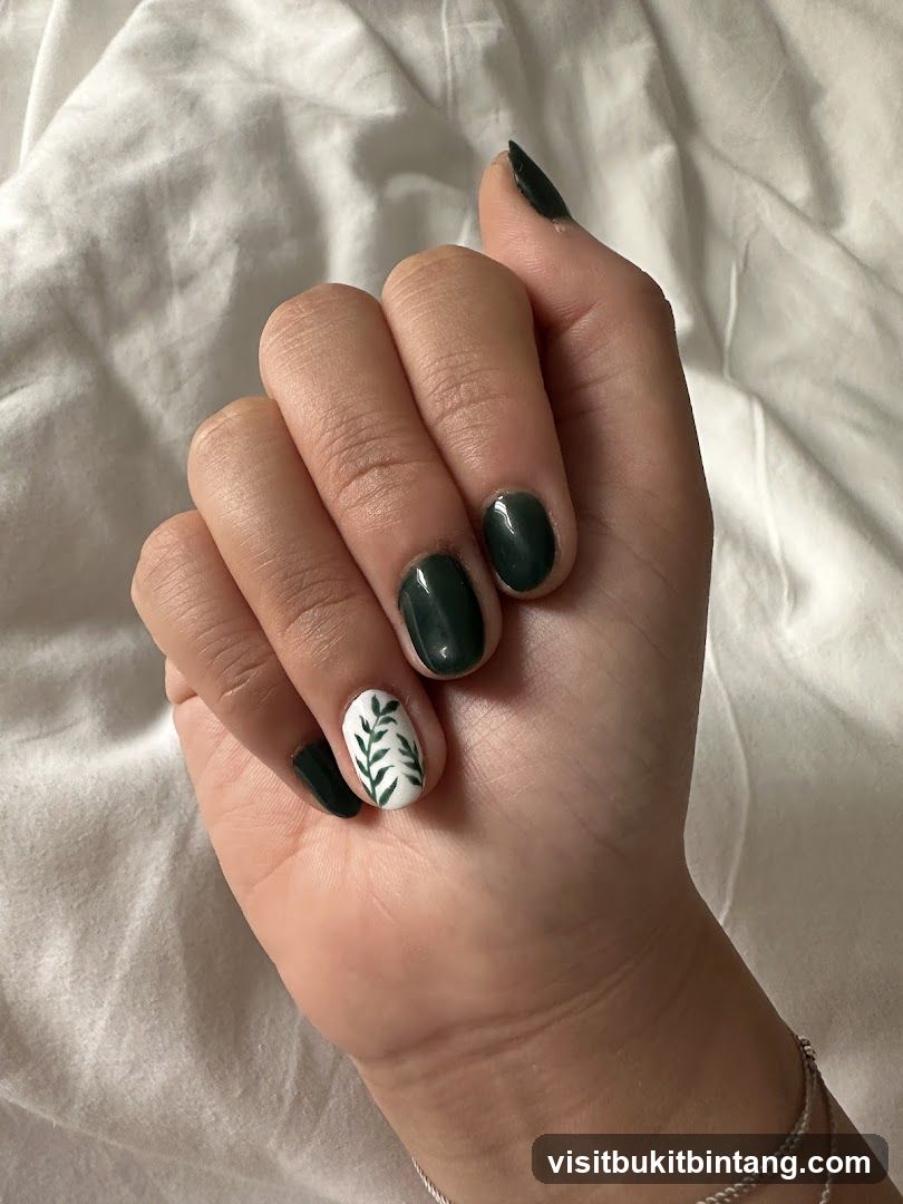 Hand with dark green nails and leaf accent