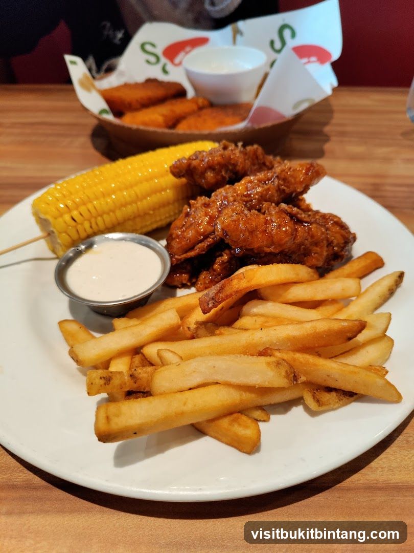 Chicken tenders with fries and corn on the cob