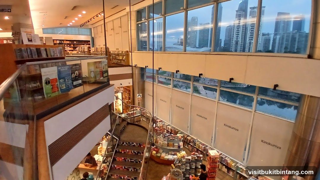 Interior of a multi-level bookstore with a view of city skyscrapers