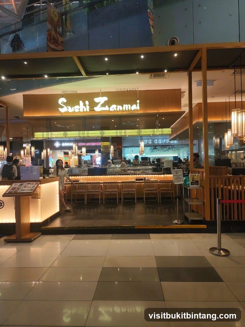 The exterior of a Sushi Zanmai restaurant with its prominent signage. The restaurant features a wooden facade and interior seating visible through the open front. A woman stands near a display stand at the entrance.