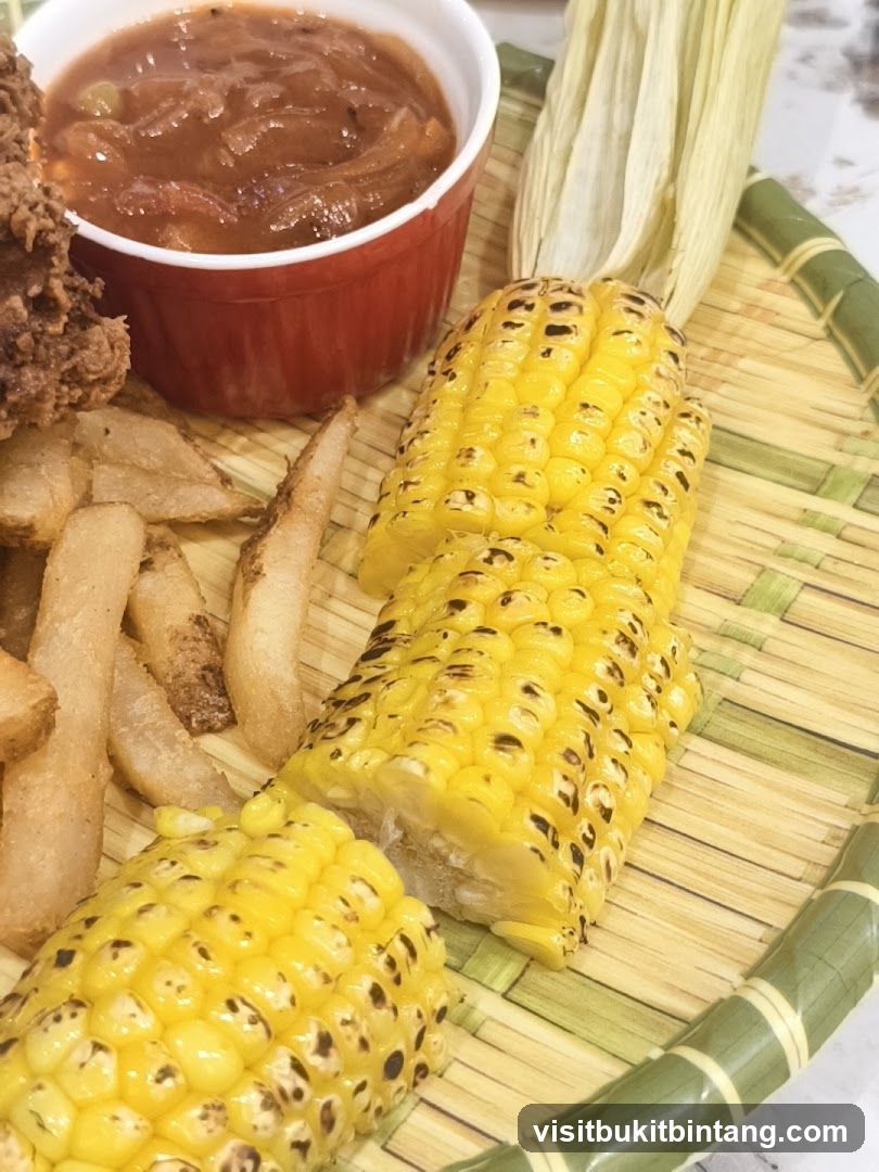 Corn on the cob with fries and sauce