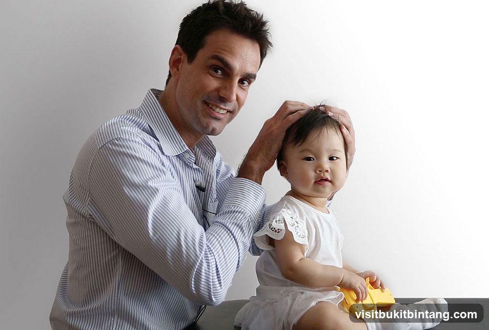 Man examining a baby's head
