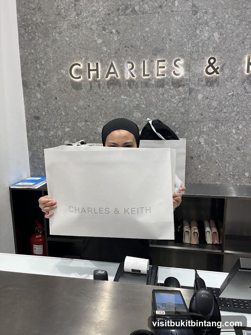 Woman holding shopping bag in front of Charles & Keith store
