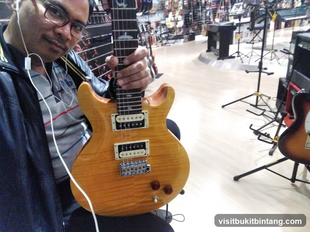 Man holding a guitar in a music store