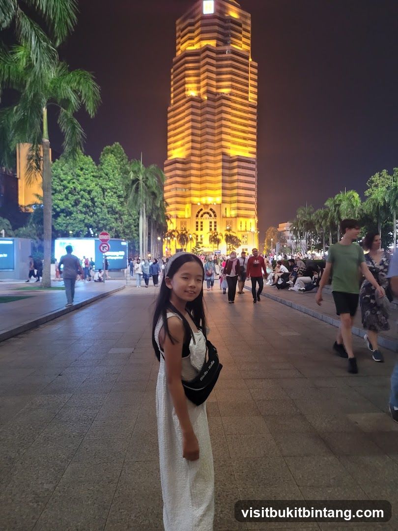 Girl in front of illuminated skyscraper