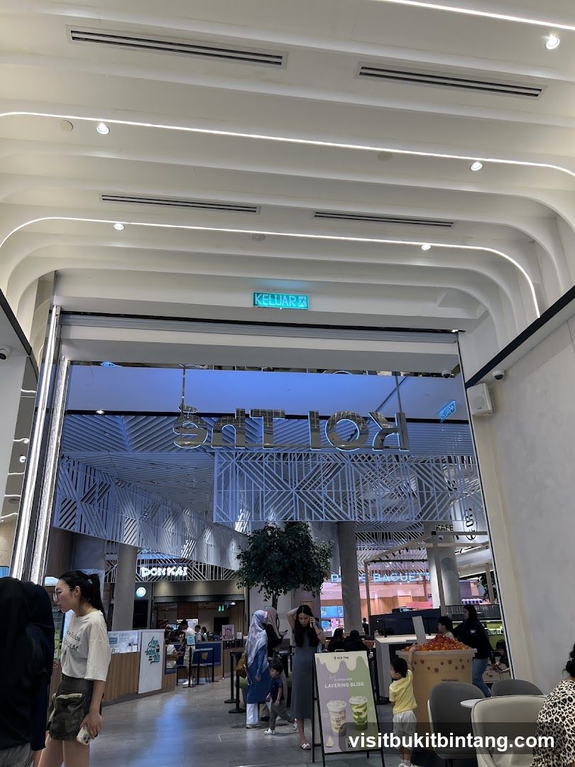 Interior of a shopping mall with various shops and people