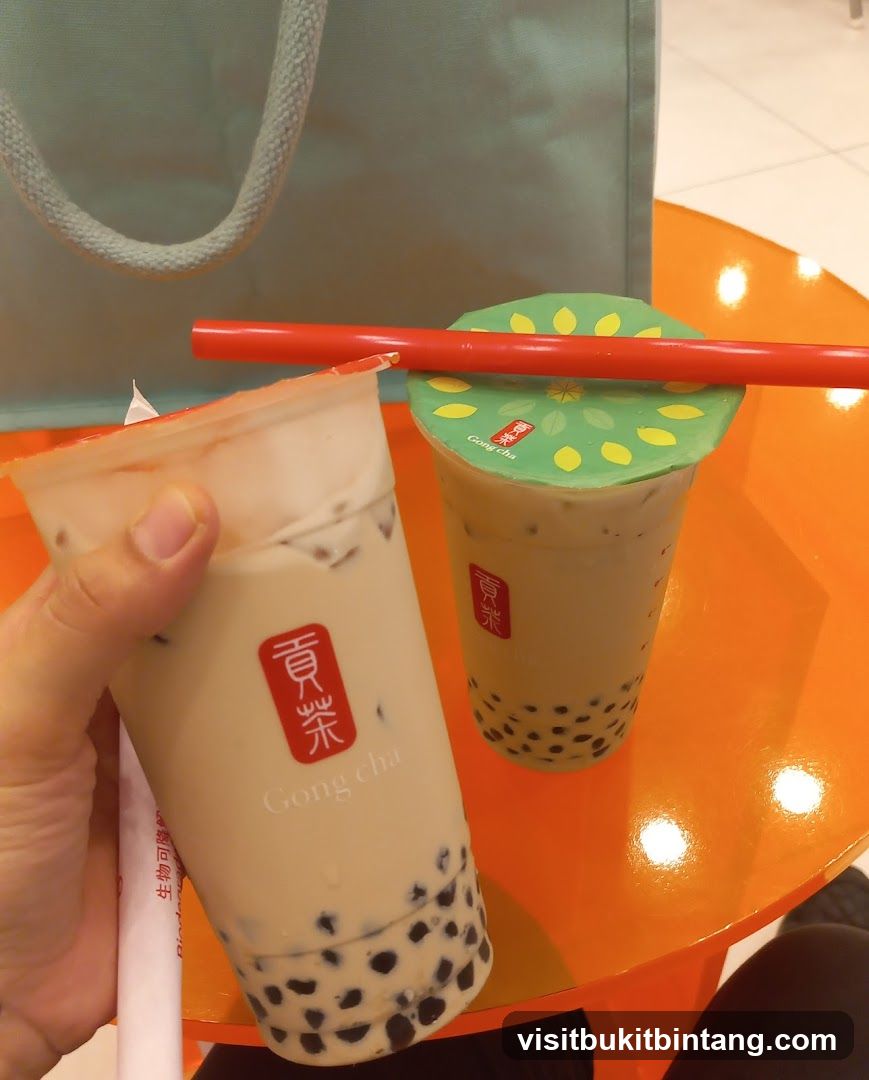 Two bubble tea drinks on an orange table