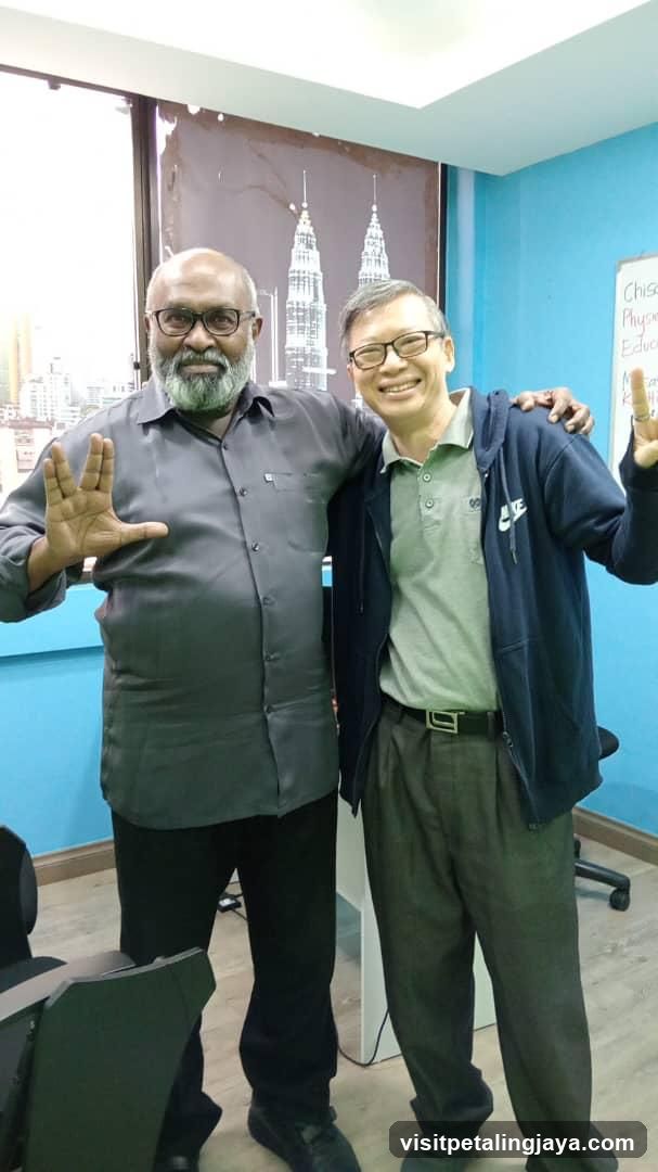 Two men posing indoors with hand gestures