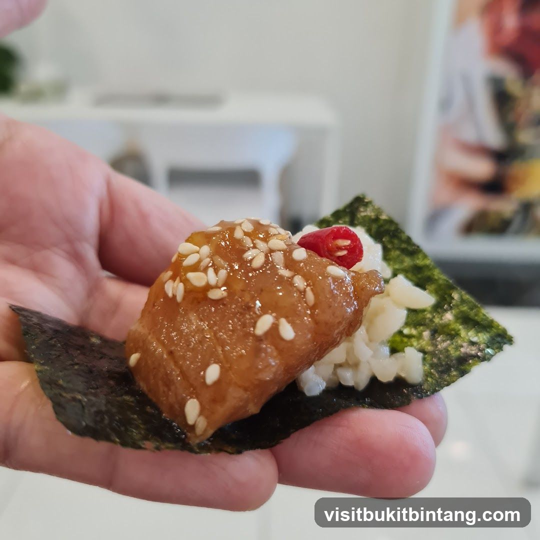 Hand holding a piece of sushi