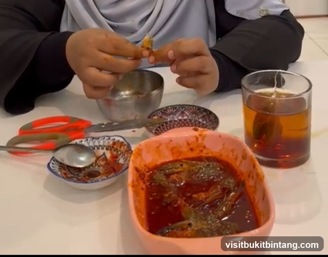 Person eating fish in sauce with tea