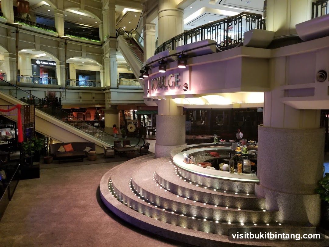 Interior of a multi-level shopping mall with a circular bar area.