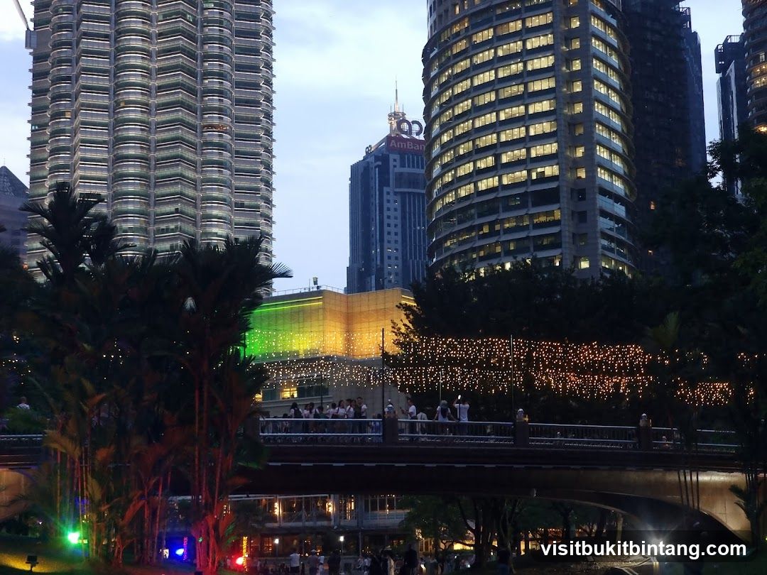 Cityscape at Dusk with Illuminated Buildings and Bridge