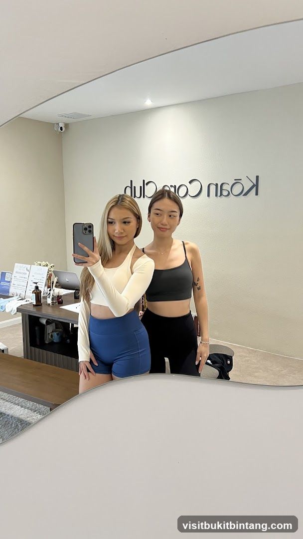 Two women taking a mirror selfie in a studio