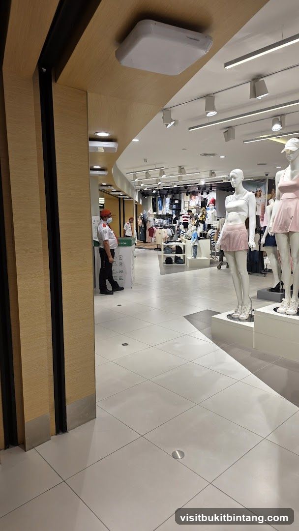 Clothing store interior with mannequins and security guard