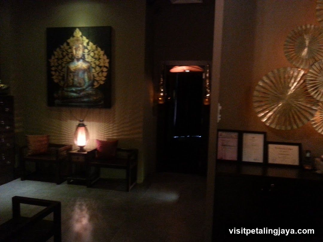 Interior of a dimly lit room with Buddha artwork and certificates