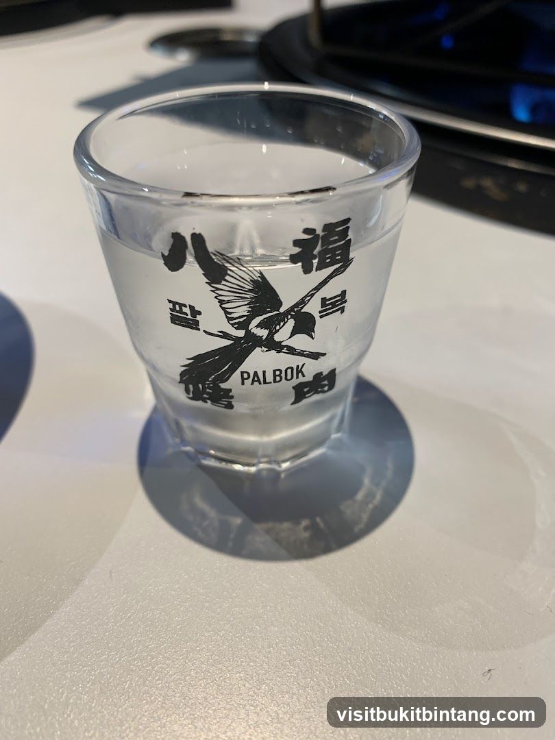 Shot glass with Korean text and magpie design