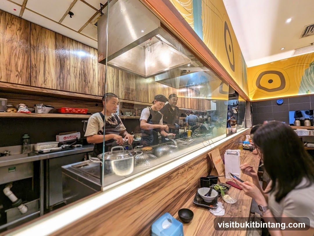 Chefs preparing food behind a glass partition