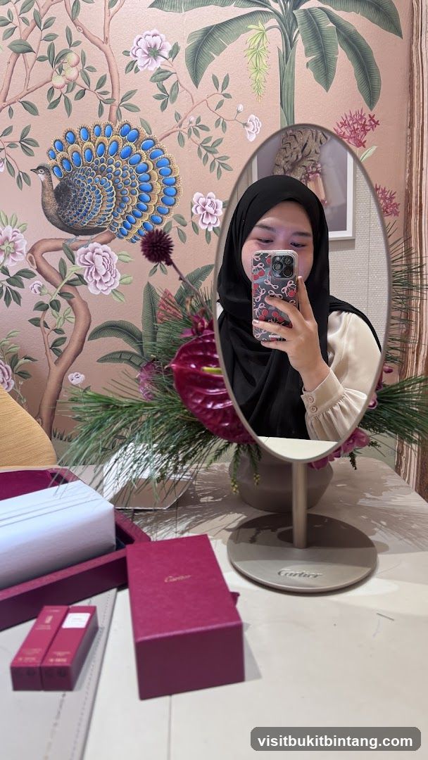 Woman taking a mirror selfie with Cartier boxes