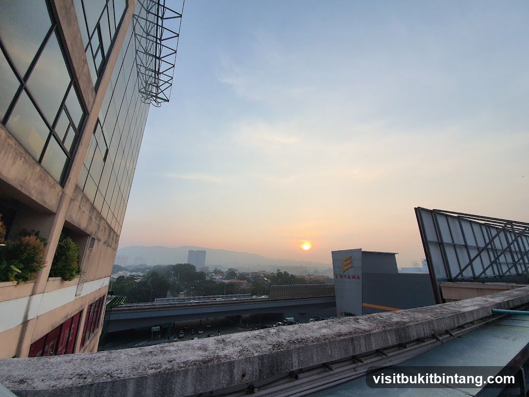 Sunrise over a city with buildings and a highway