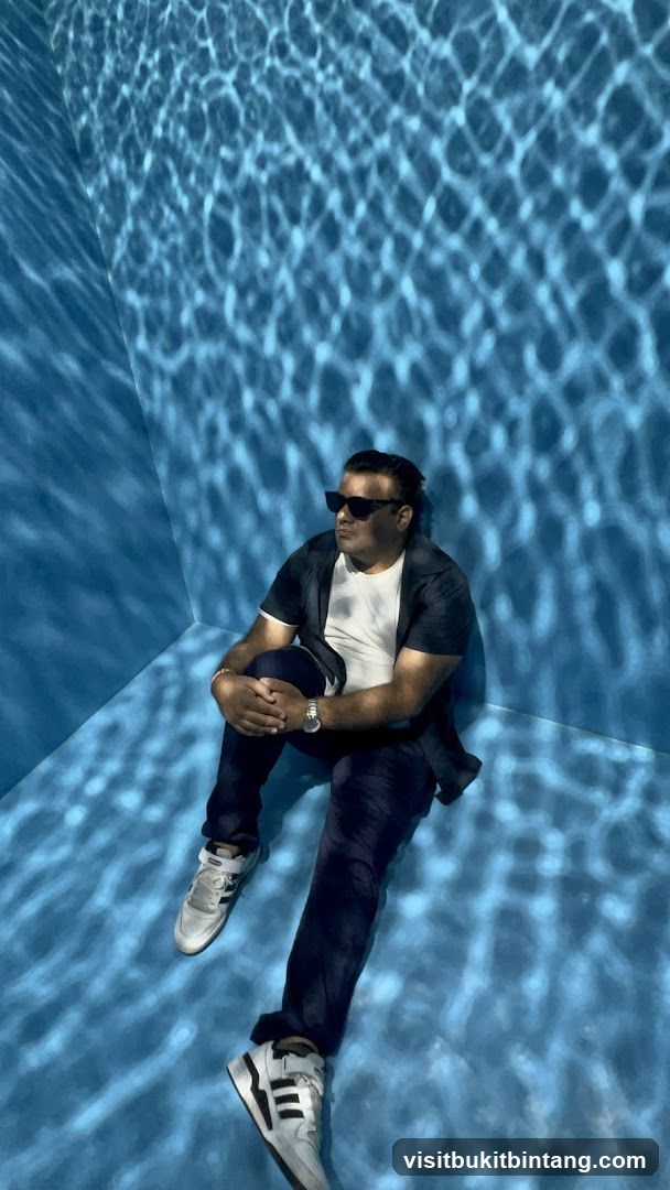 Man sitting in a room with water-like light projections