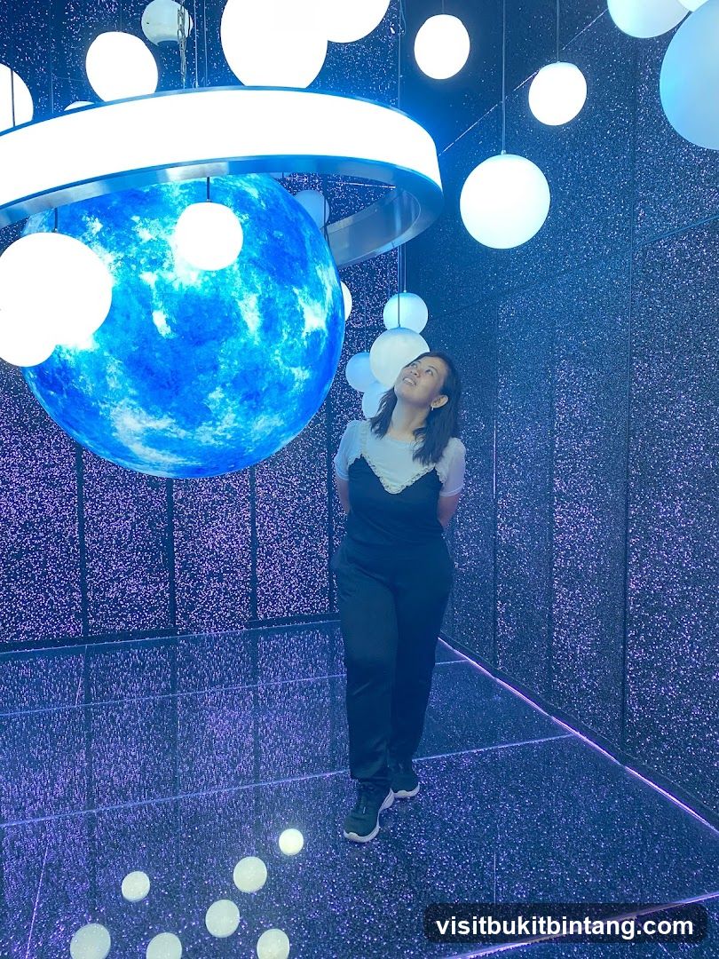Woman in a room with a large blue sphere and lights