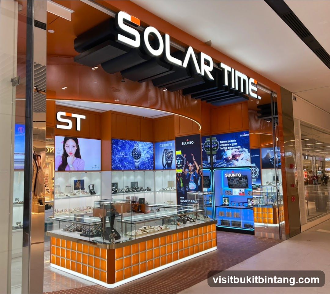 The exterior of a watch store called Solar Time. The store has a bright orange facade with illuminated signage. Inside, display cases showcase various watches, and digital screens display advertisements for watch brands like Suunto and Cerruti.