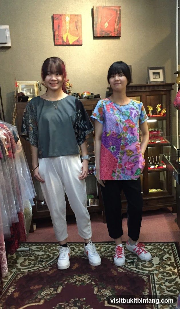Two young women posing in a boutique