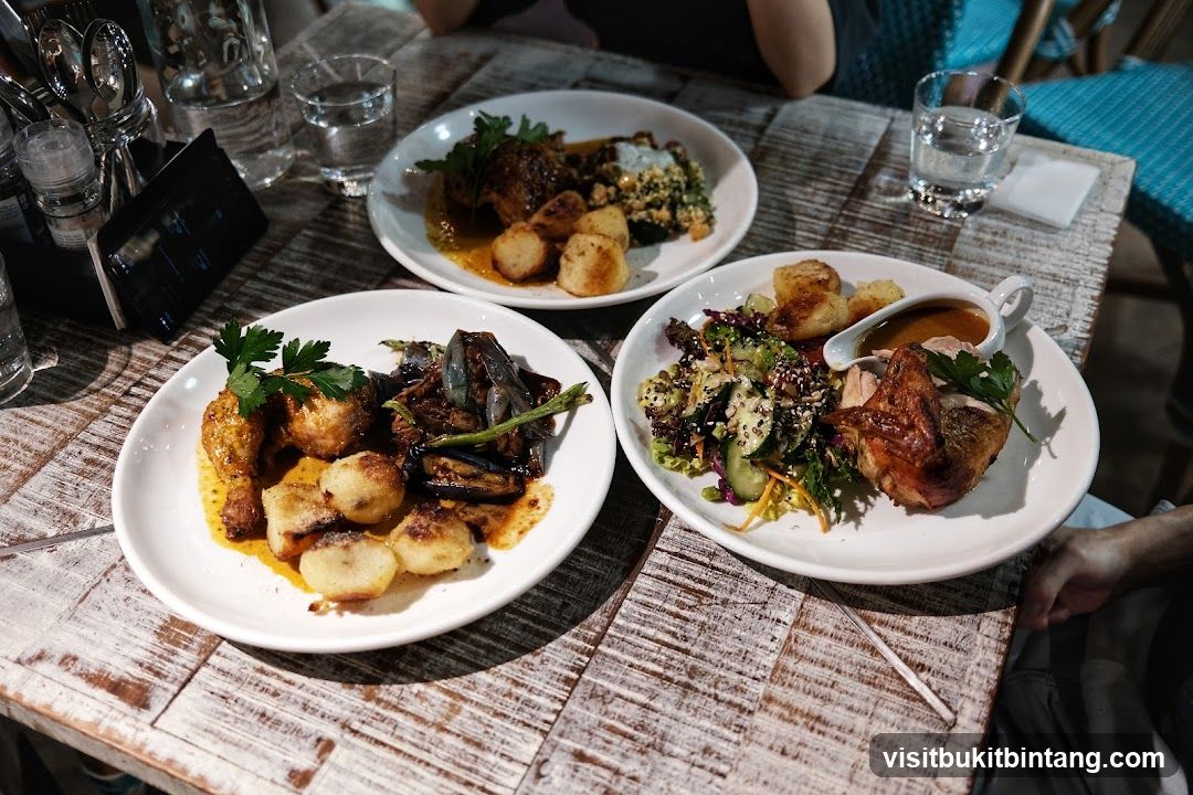 Three plates of food on a wooden table
