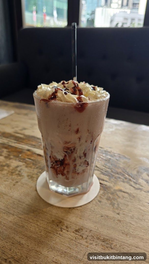Strawberry milkshake with whipped cream and chocolate drizzle
