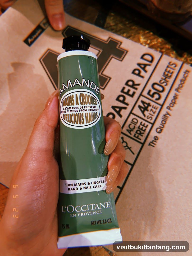 Hand holding L'Occitane hand cream
