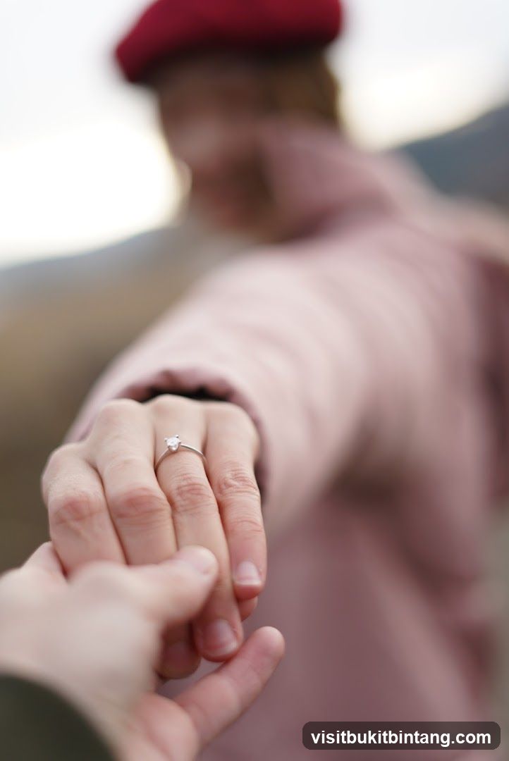 Couple holding hands with engagement ring