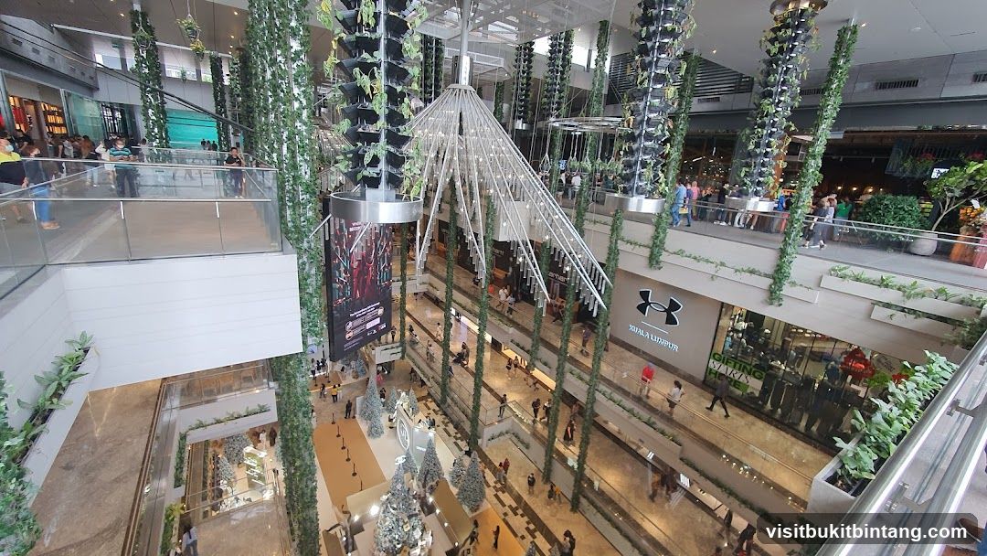 Indoor shopping mall with greenery and shops