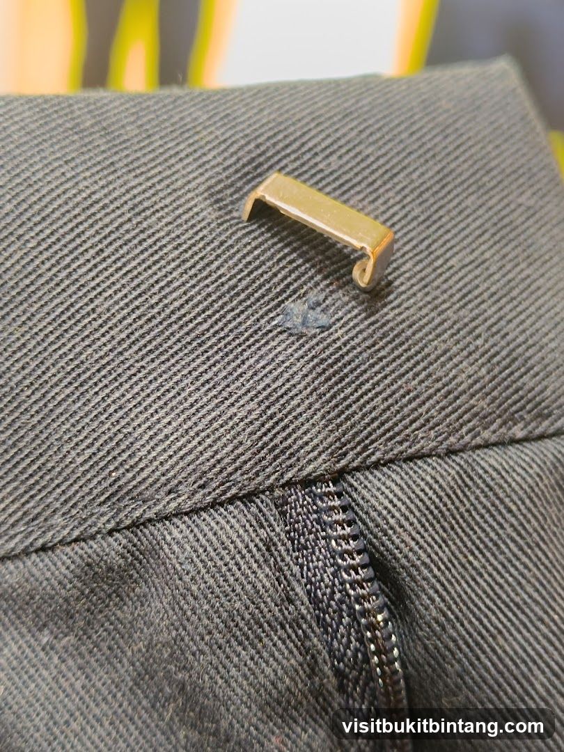 Close-up of a Zipper and Button Tab on Dark Fabric