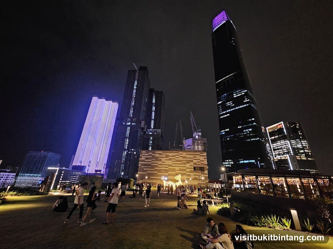 Nighttime cityscape with people in a park