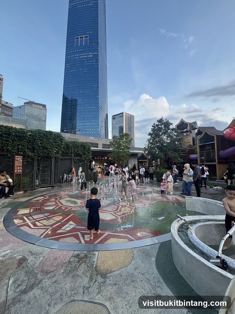 Children playing in a water fountain area with skyscrapers in the background