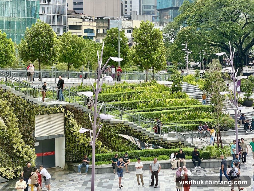 People in a park with tiered gardens and modern architecture