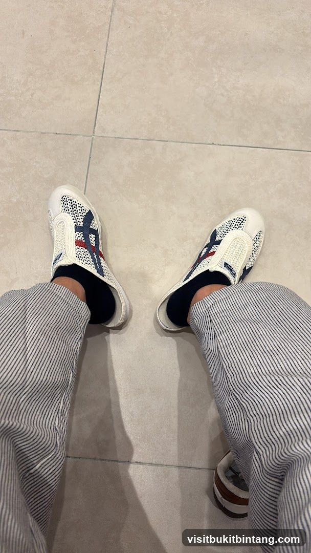 Person Wearing White Slip-On Shoes and Striped Pants