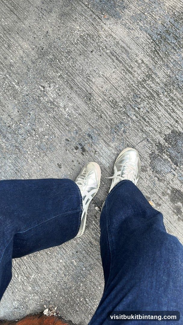 Person wearing silver sneakers and blue jeans
