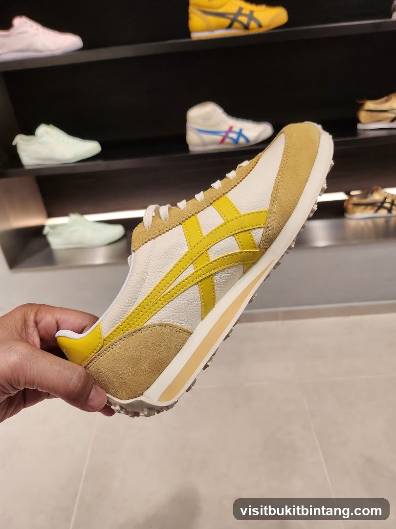 Hand holding a yellow and white sneaker