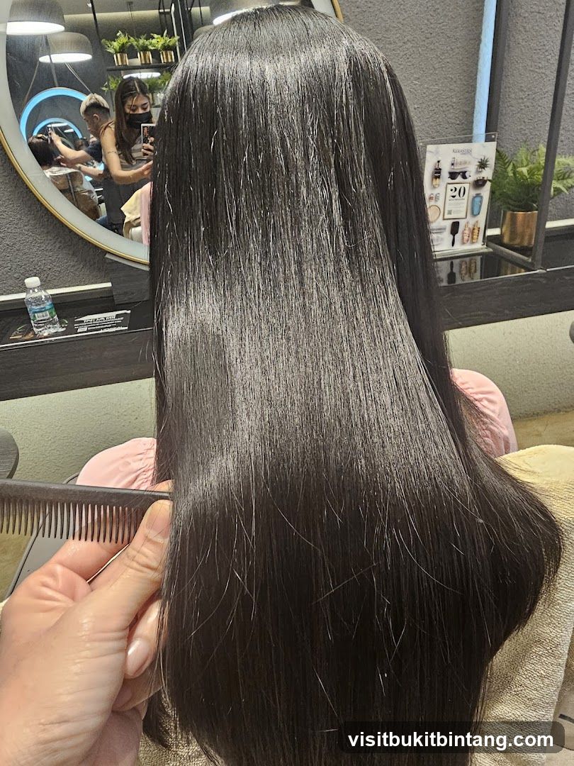 Hairdresser combing client's long dark hair