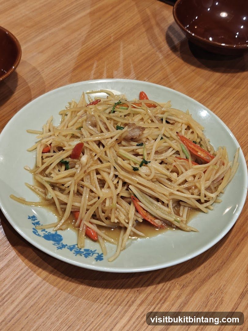 Stir-fried shredded potatoes with chili and herbs