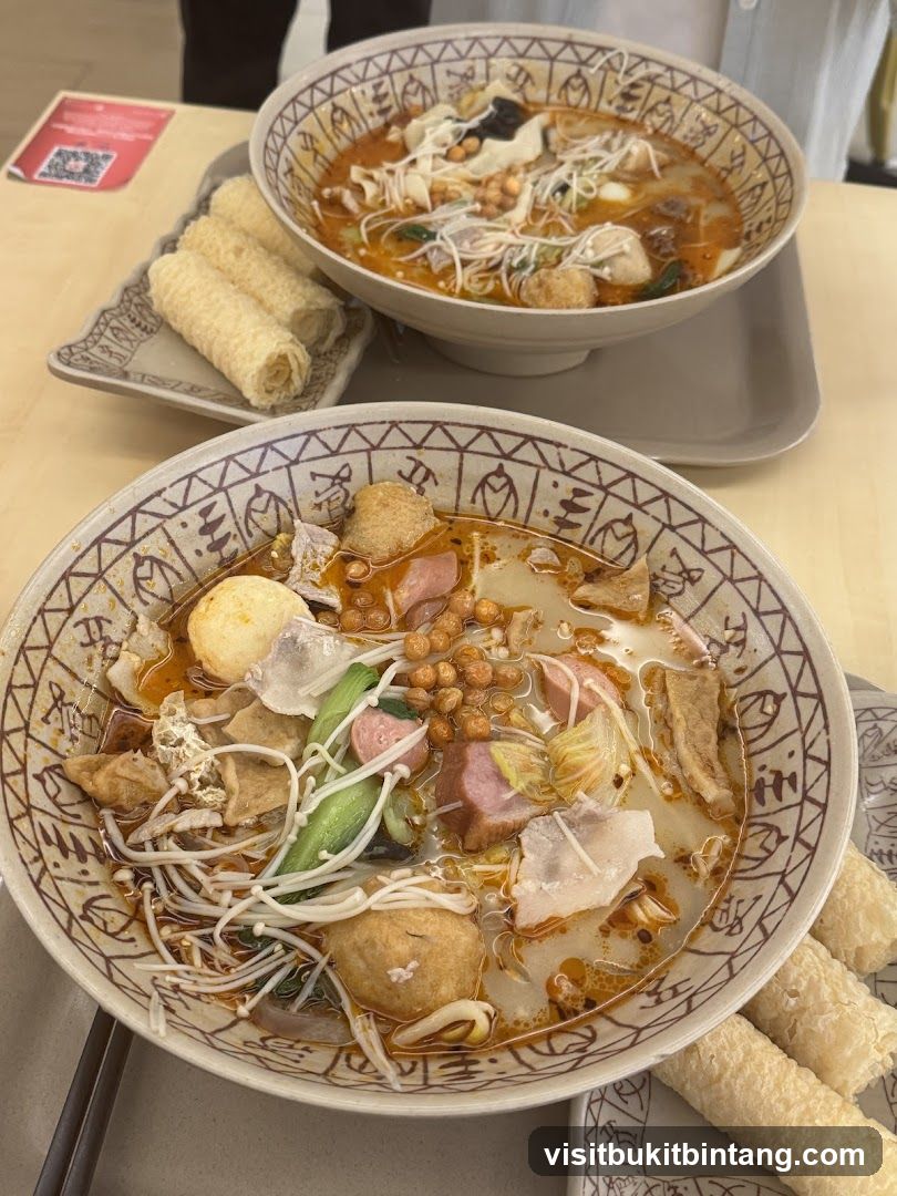 Two bowls of spicy soup with various ingredients