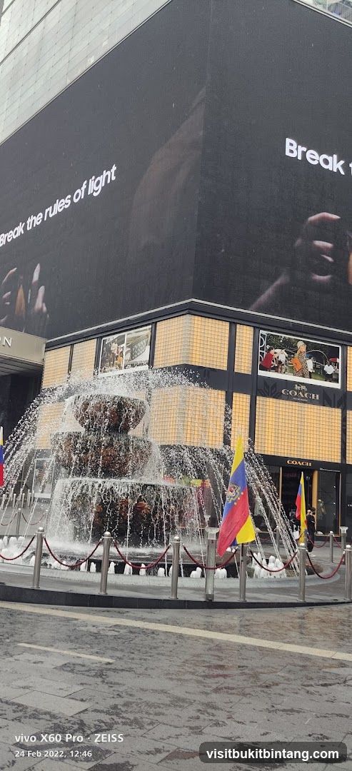 Fountain in front of a building with advertisements